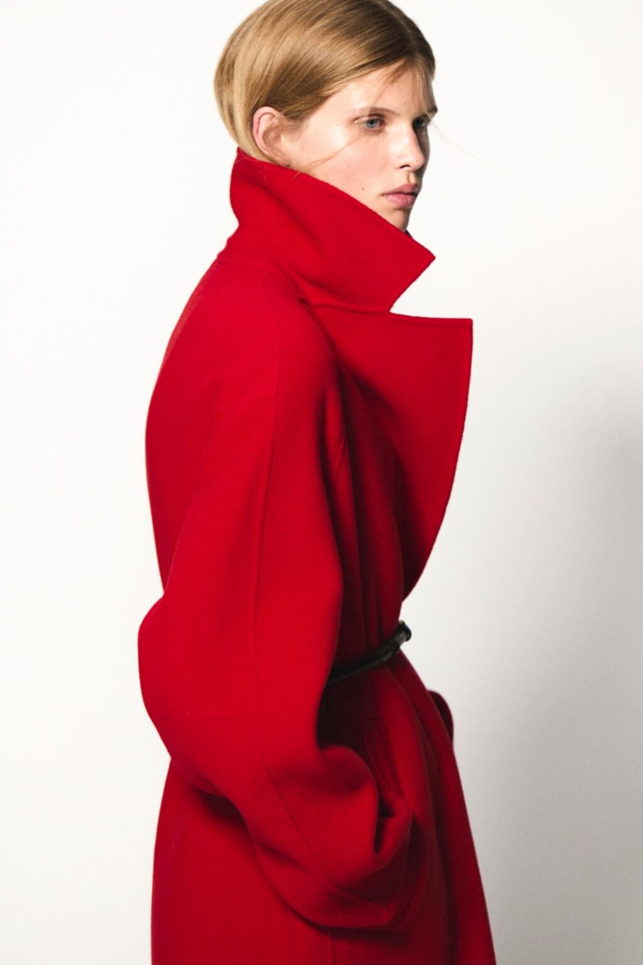 woman wearing red coat with exaggerated collar