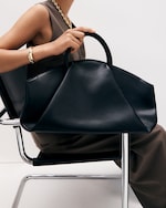 Placeholder for: woman with large leather fold bag