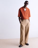 Placeholder for: man in orange top and camel pants