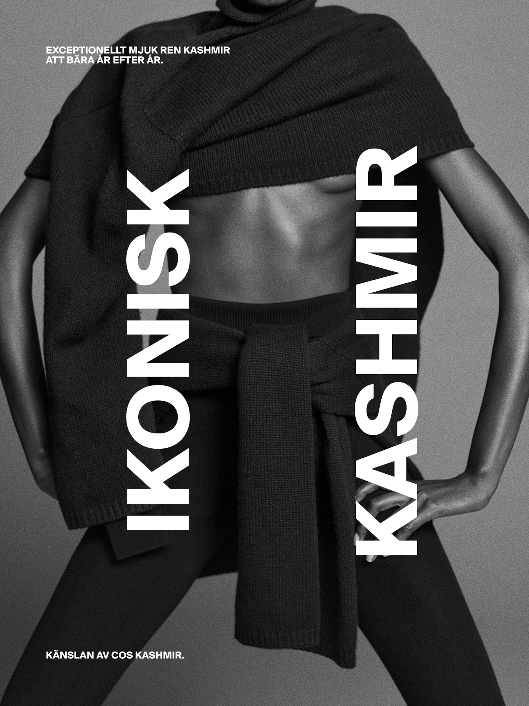 Black and white image of a person wearing a black cashmere wrap and leggings, with bold text "IKONISK KASHMIR" displayed vertically.