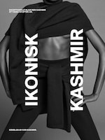 Placeholder for: Black and white image of a person wearing a black cashmere wrap and leggings, with bold text "IKONISK KASHMIR" displayed vertically.