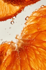 Placeholder for: Close-up of juicy orange slices with water droplets, showing detailed texture and vibrant orange color against a light background.