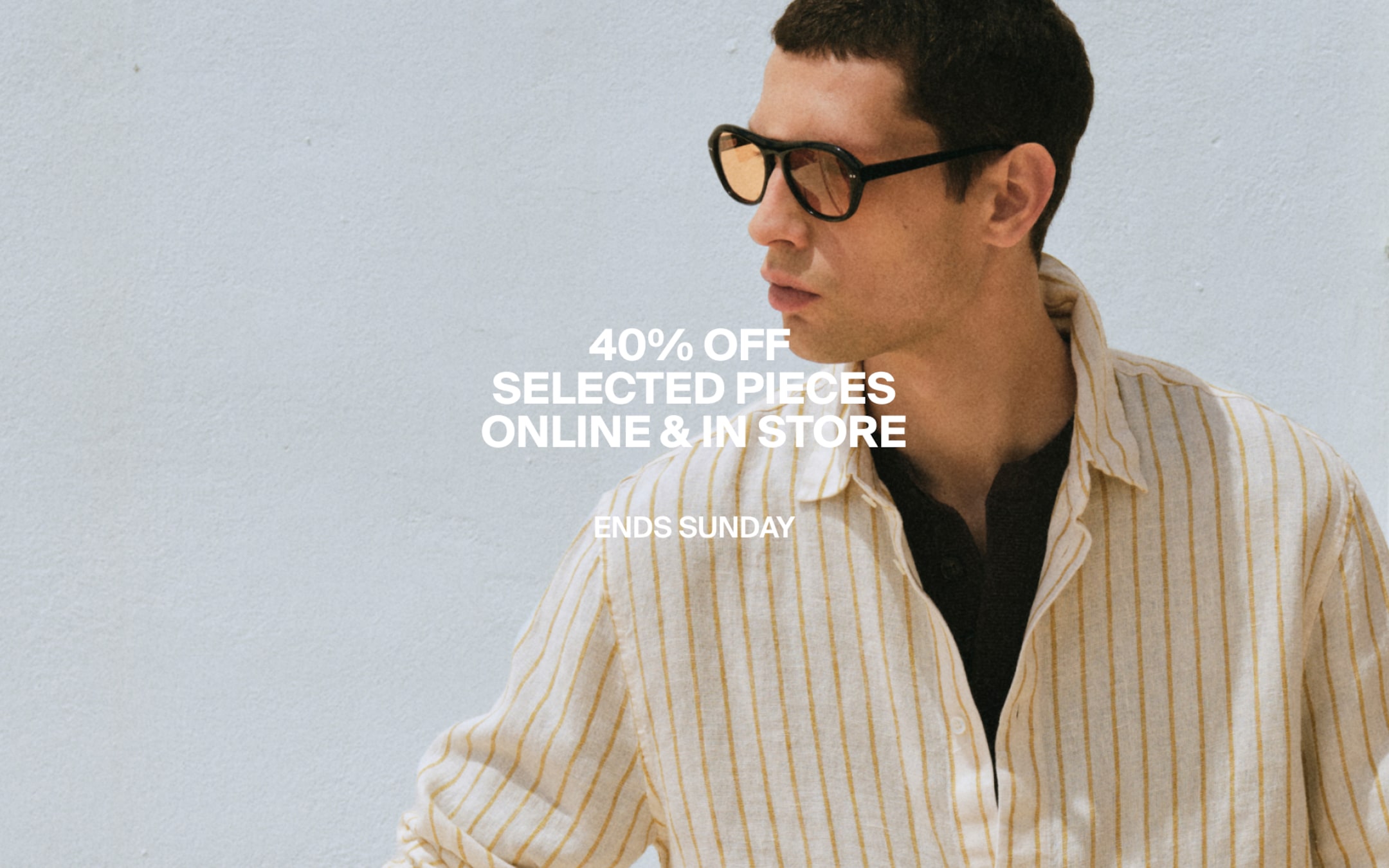 Man in striped shirt and sunglasses against a light wall, with text "40% OFF SELECTED PIECES ONLINE & IN STORE. ENDS SUNDAY."