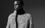 Placeholder for: Black and white portrait of a person in a textured knit sweater, gazing thoughtfully to the side.