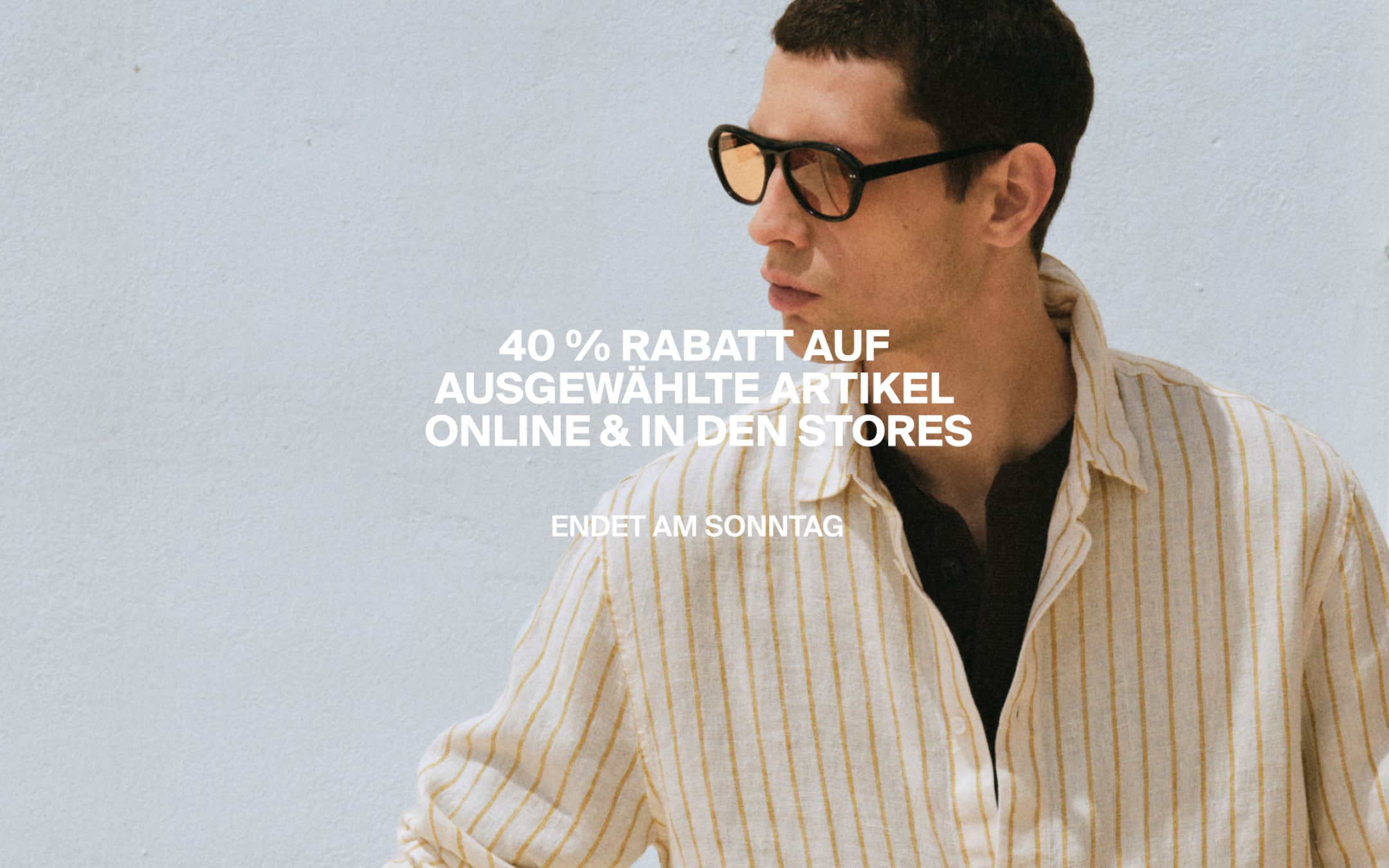 Person in sunglasses and a striped shirt stands against a light background with German text about a 40% sale ending Sunday.