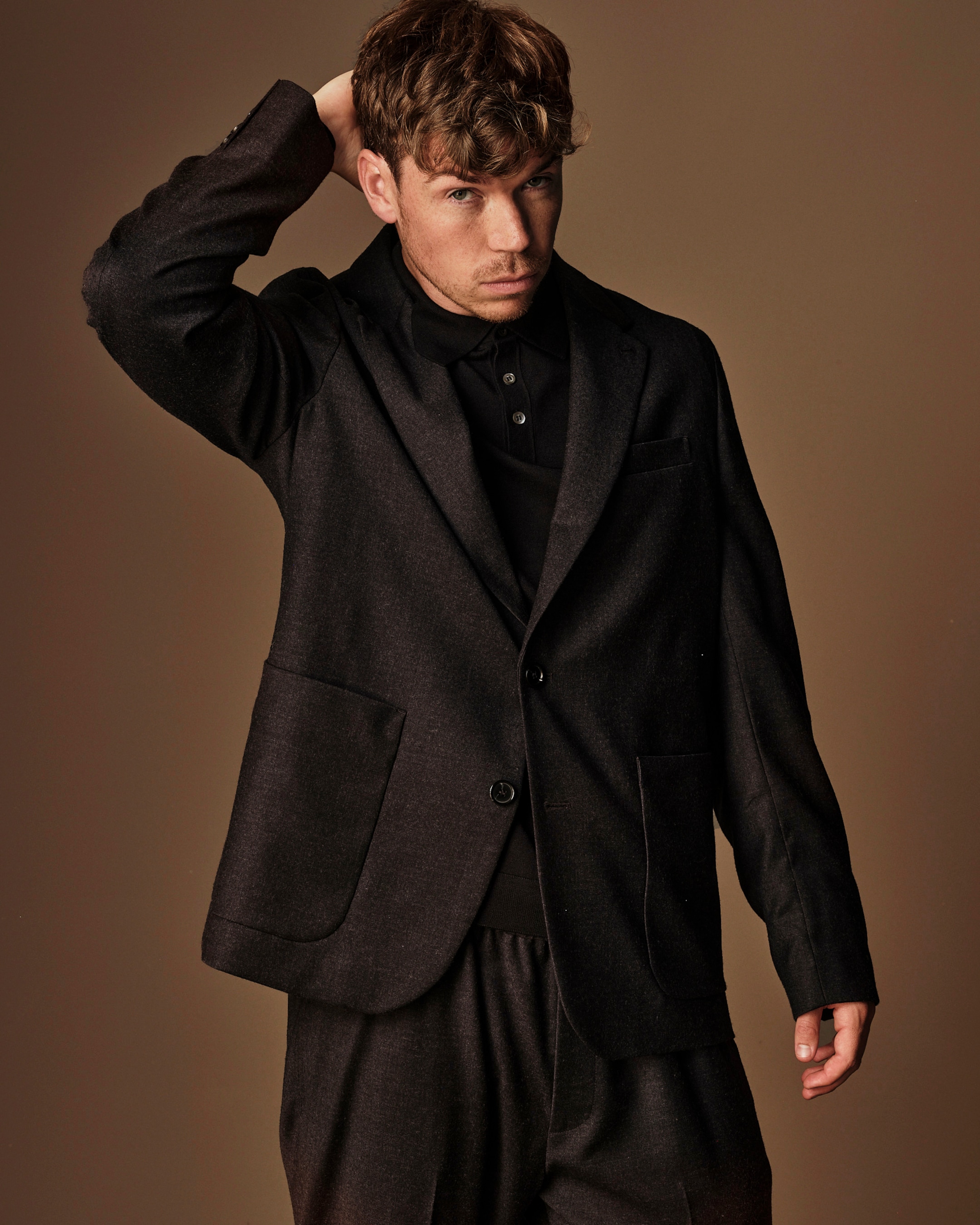 Will Poulter wearing brown suit