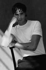 Placeholder for: Man wearing white t-shirt and trousers whilst sitting on a chair