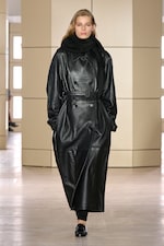 Placeholder for: Person walking on a runway wearing a black leather coat