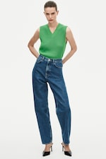 Placeholder for: Woman wearing green knitted vest and blue jeans