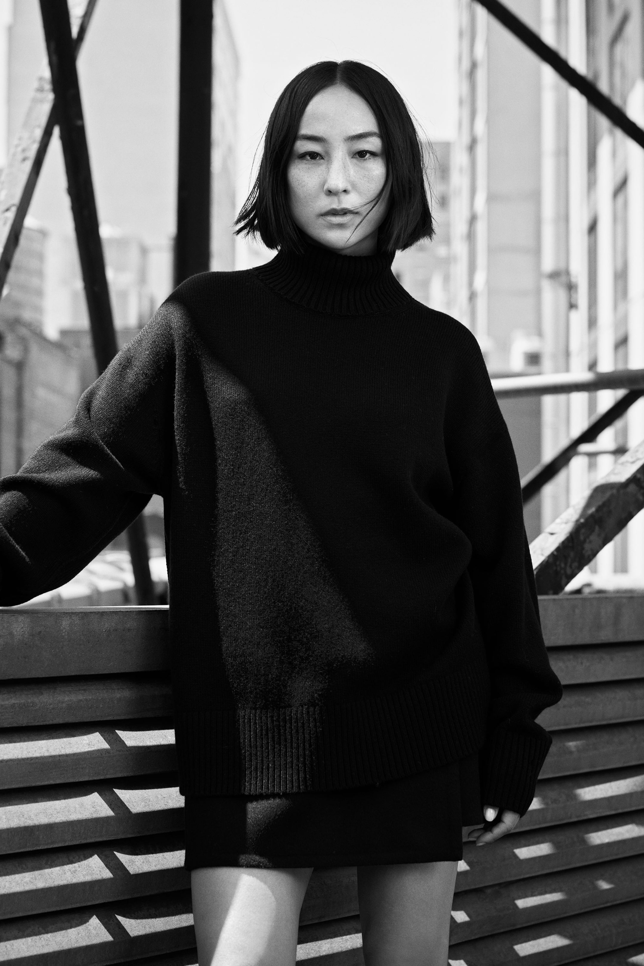 Greta Lee wearing COS black jumper and COS black skirt