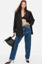Placeholder for: Woman wearing black blazer, bralette and blue jeans