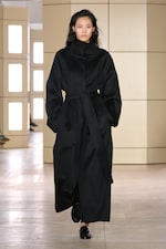 Placeholder for: Person walking on a runway wearing a black coat