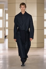 Placeholder for: Person walking on a runway wearing a dark coat