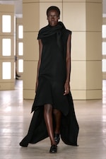 Placeholder for: Person walking on a runway wearing a black dress