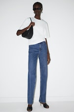 Placeholder for: Woman wearing white top and blue straight leg jeans