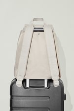 Placeholder for: Beige backpack sitting on top of black suitcase