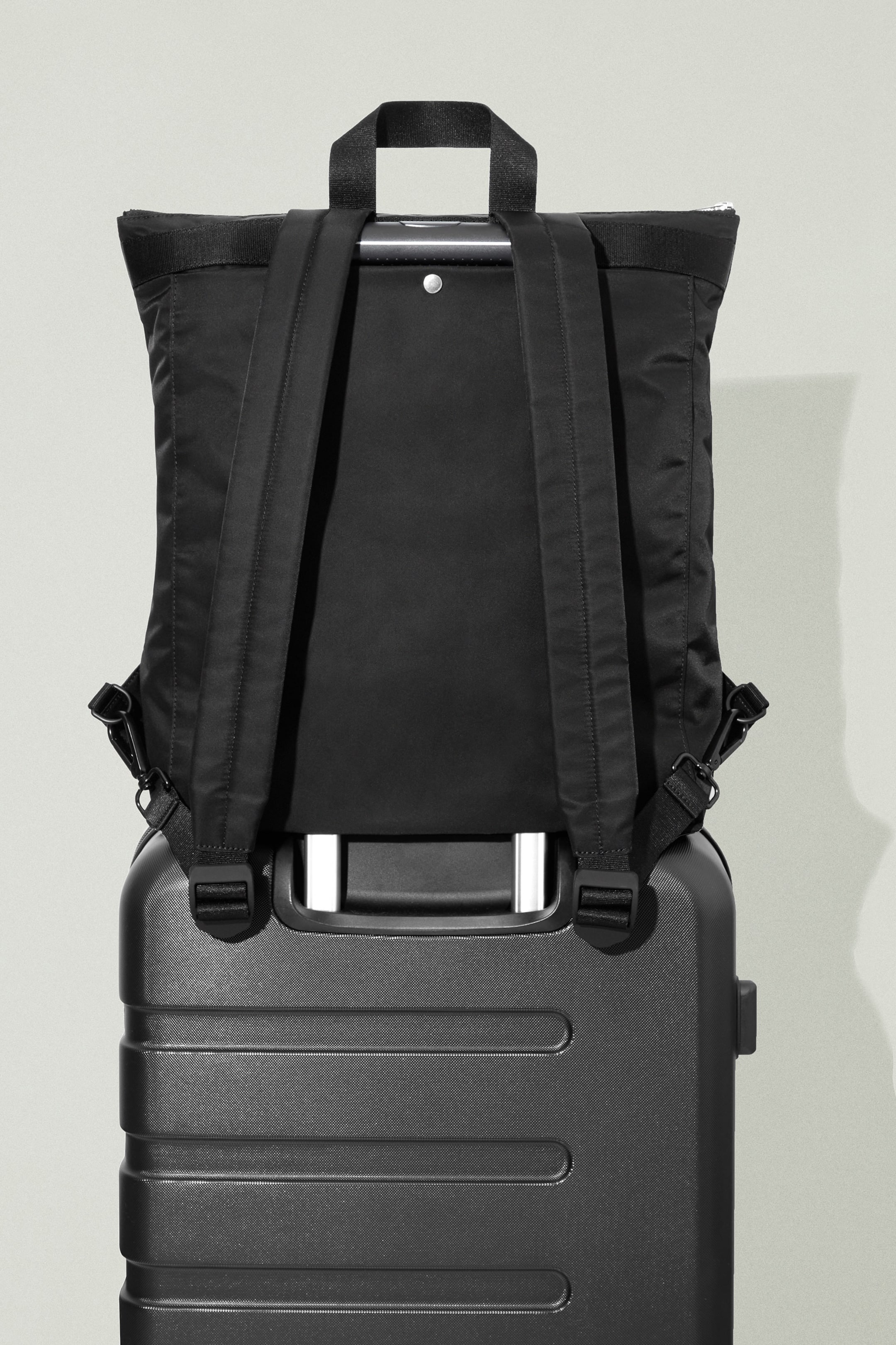 Black rucksack on black suitcase