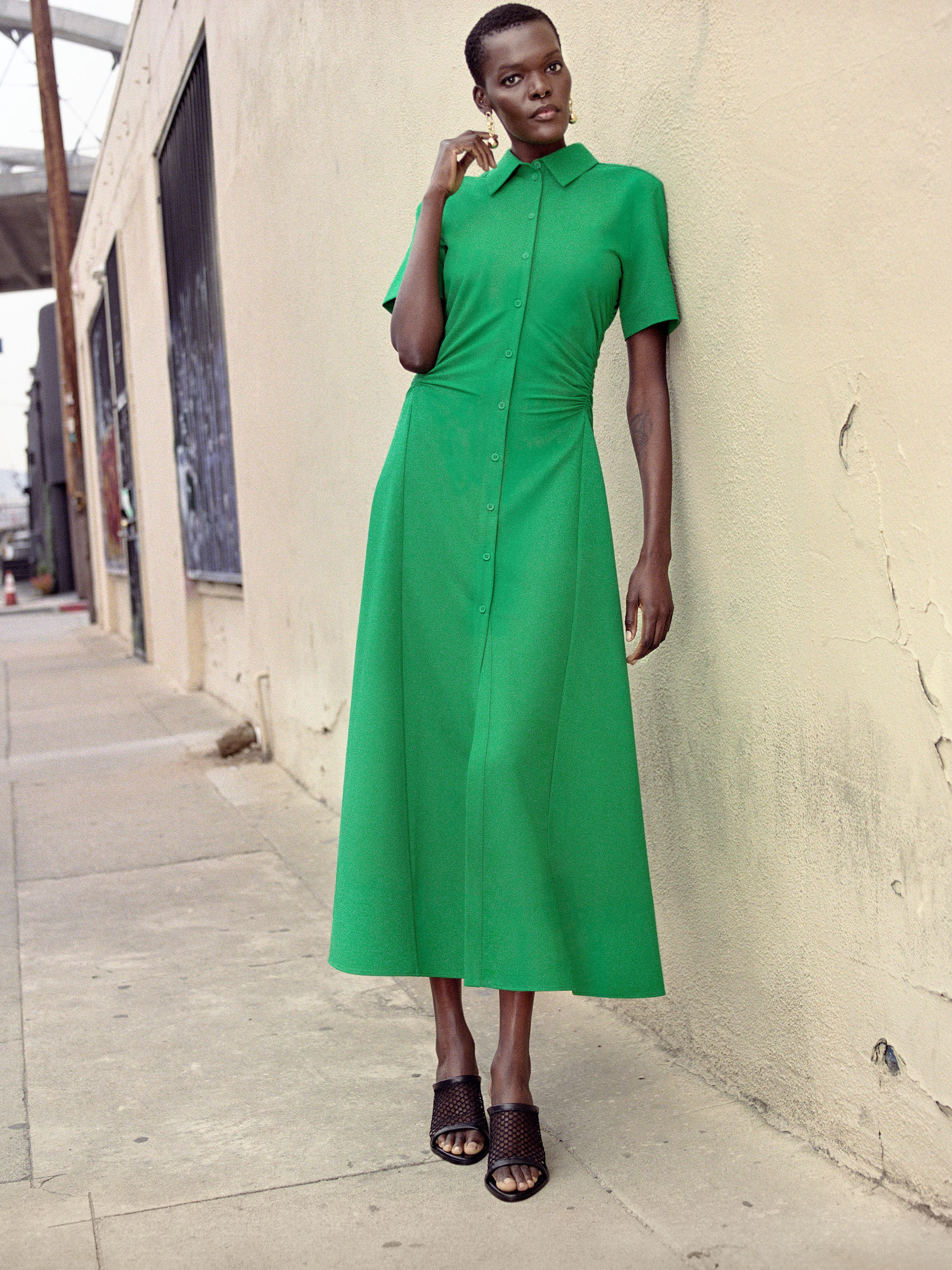 Sheila Atim wearing green dress and black shoes