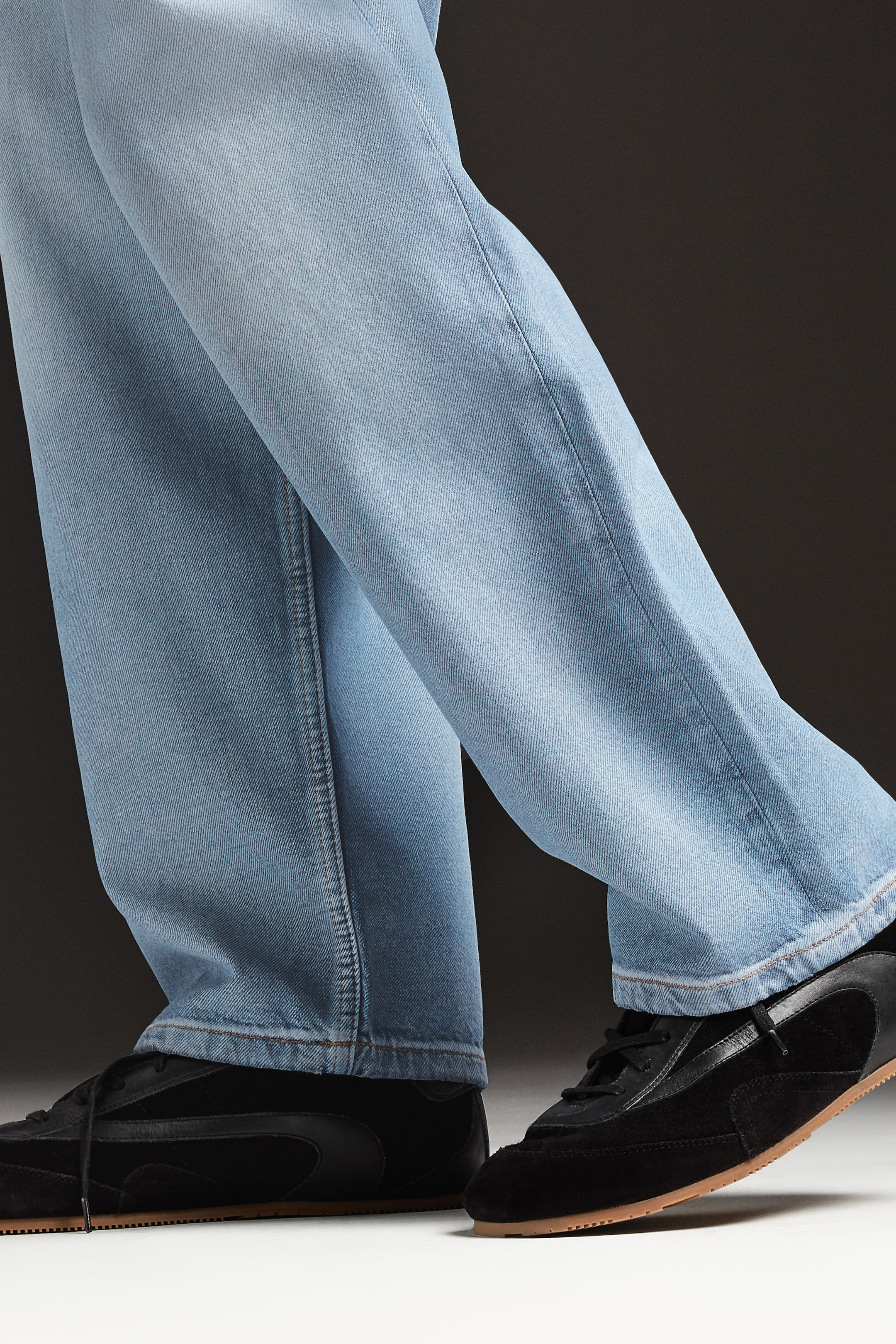Person wearing jeans and black trainers