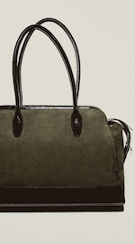 Placeholder for: A stylish black handbag with sleek leather handles and accents, set against a plain background.