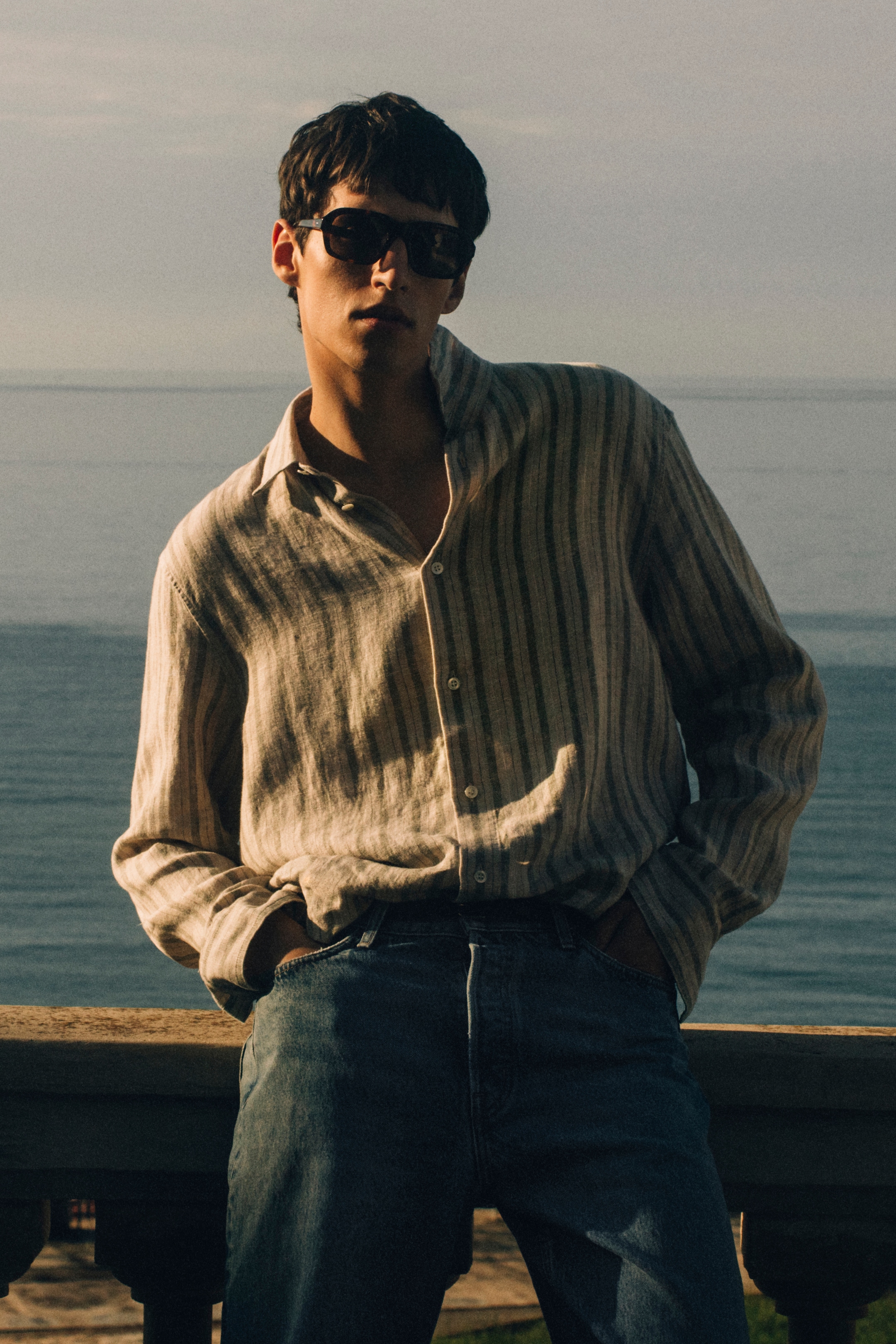 Man in sunglasses waering a striped linen shirt