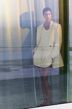 Placeholder for: woman in beige blazer, white top and cream satin shorts