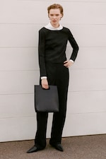 Placeholder for: Women in white shirt and black top with black clutch bag