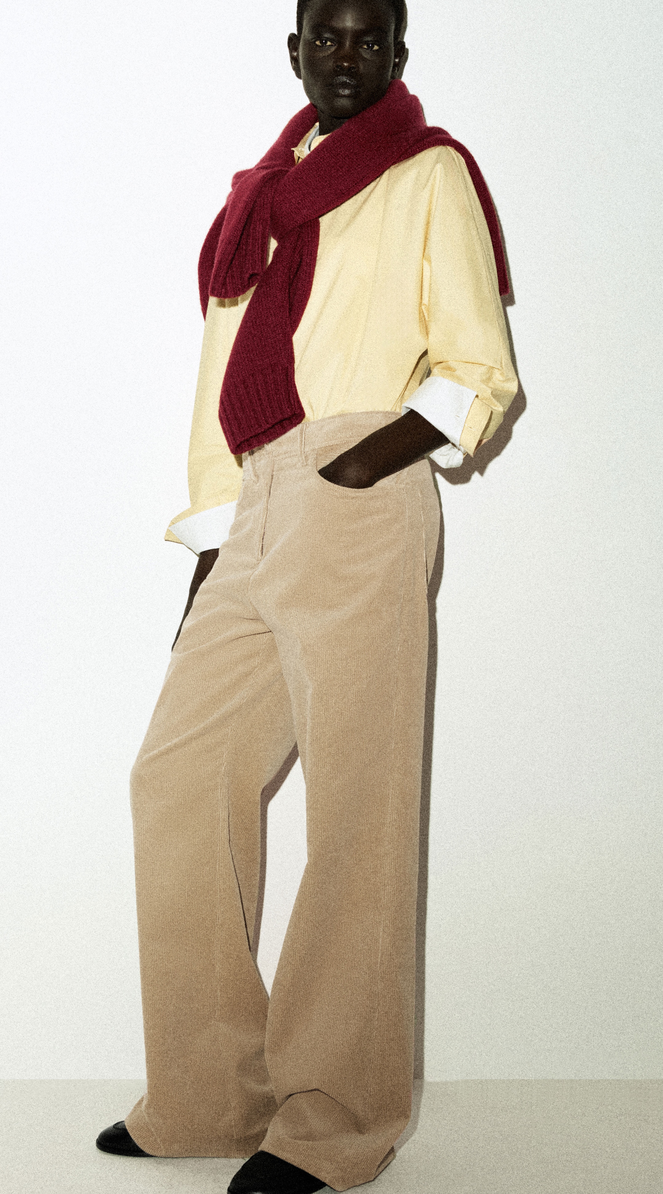 model wearing yellow shirt and red knitwear