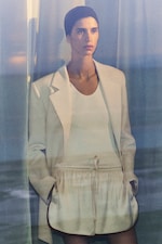 Placeholder for: woman in beige blazer, white top and cream satin shorts