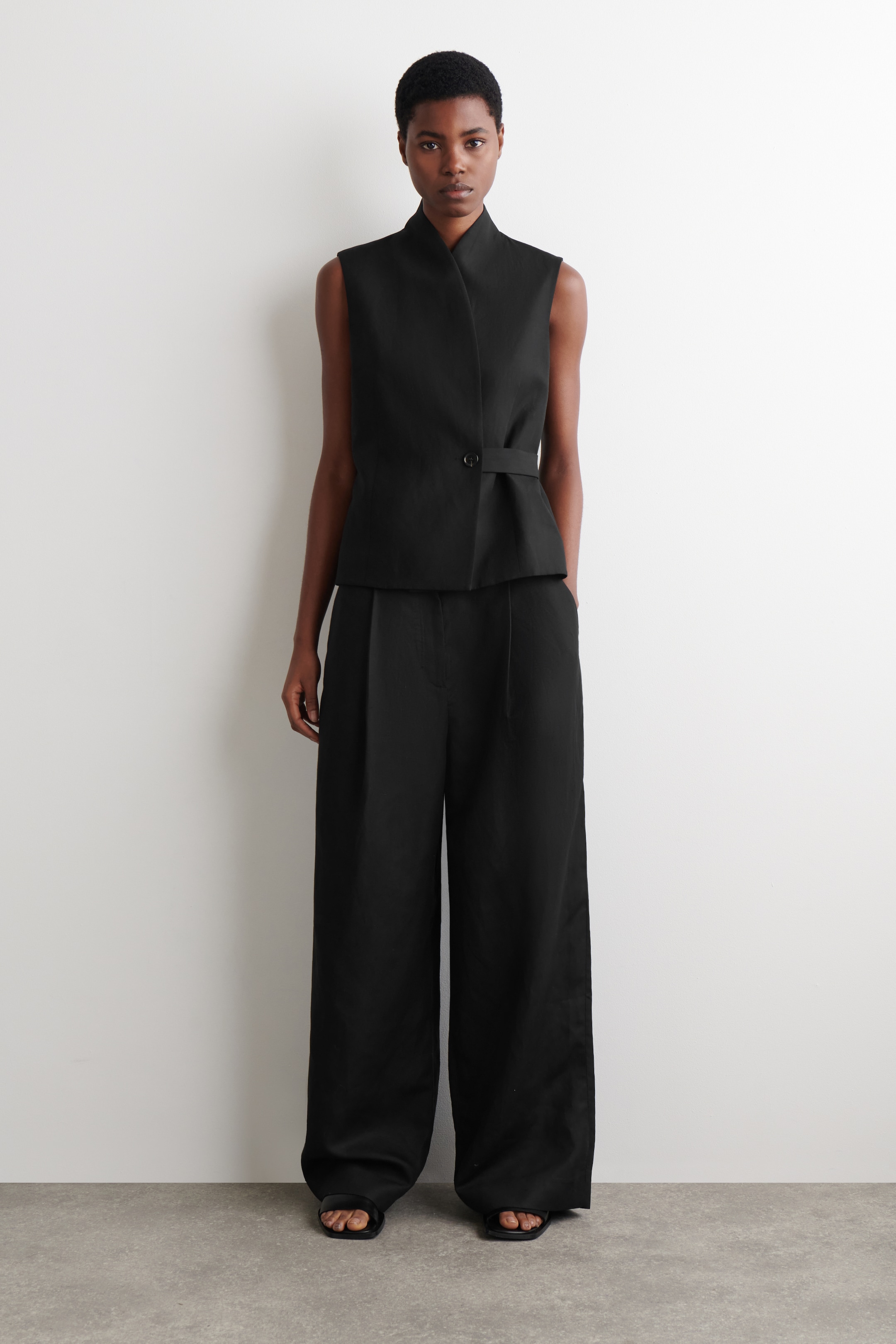 woman in black sleeveless waistcoat and wide leg trousers