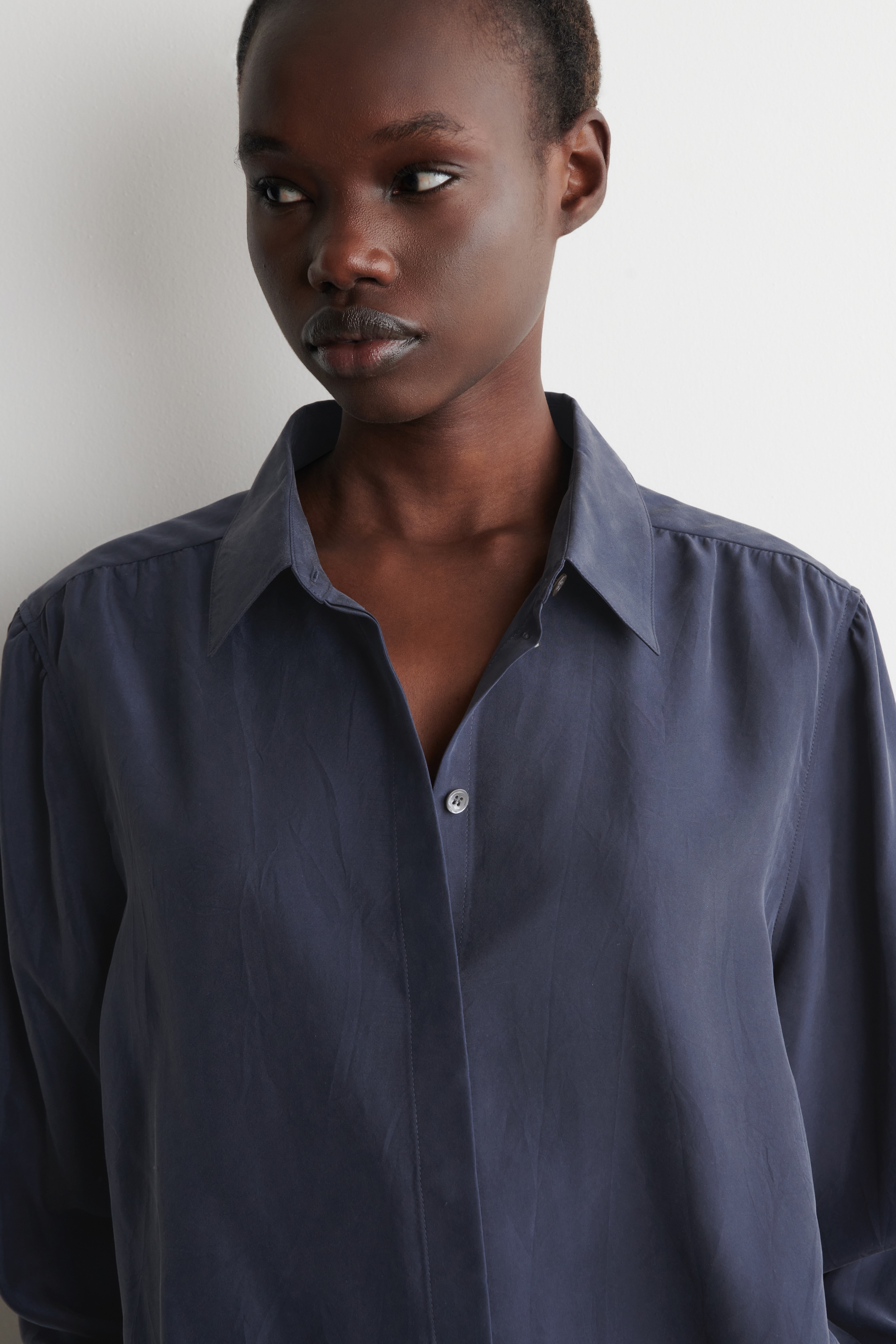 woman in navy silkk shirt close up