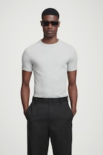 Placeholder for: Man in grey top and black trousers