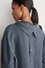 Placeholder for: woman in navy silk top showing back detail
