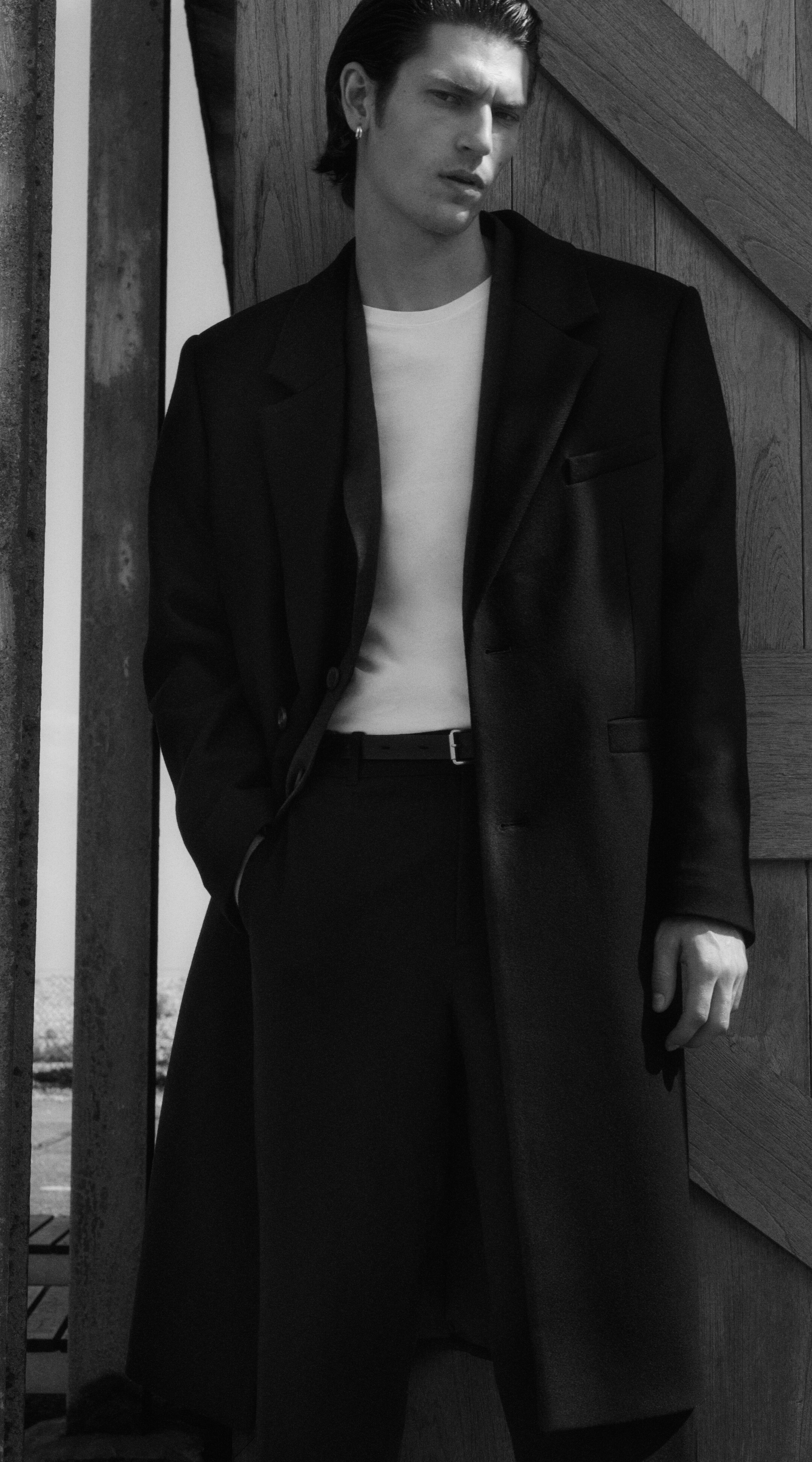 Man wearing smart coat, tshirt and trousers with leather belt