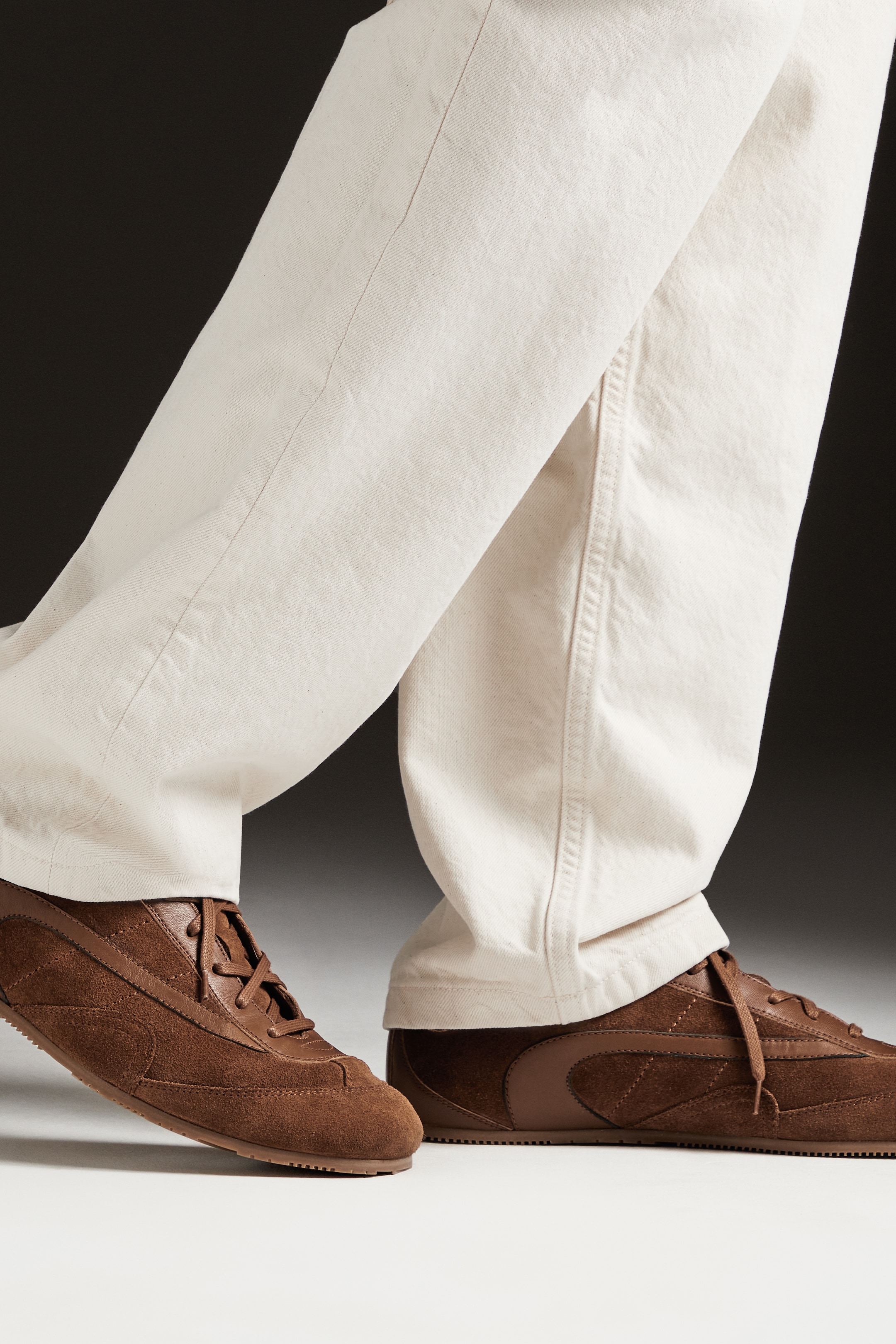 Person wearing white trousers and brown trainers