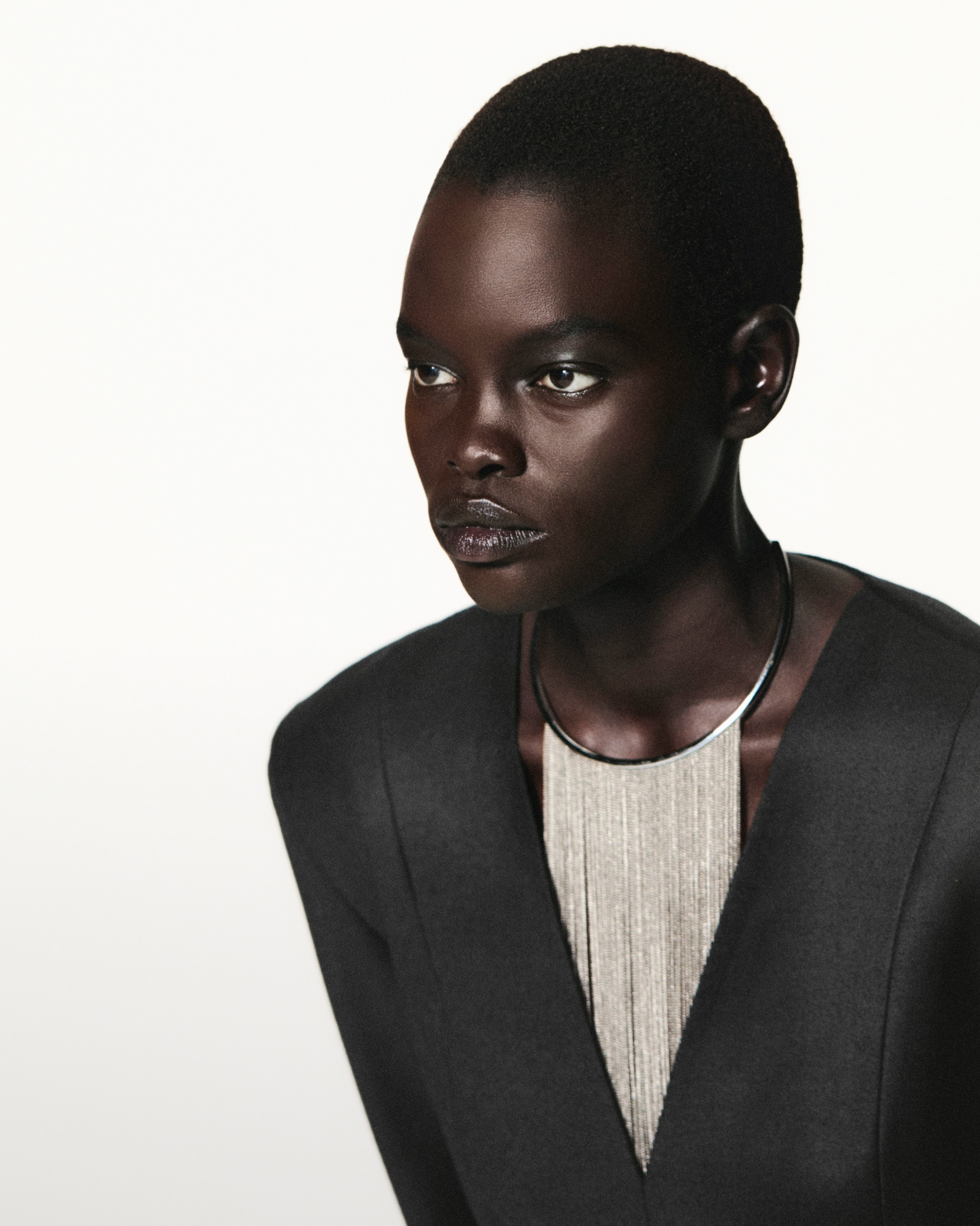 PERSON WEARING SILVER NECKLACE AND black blazer