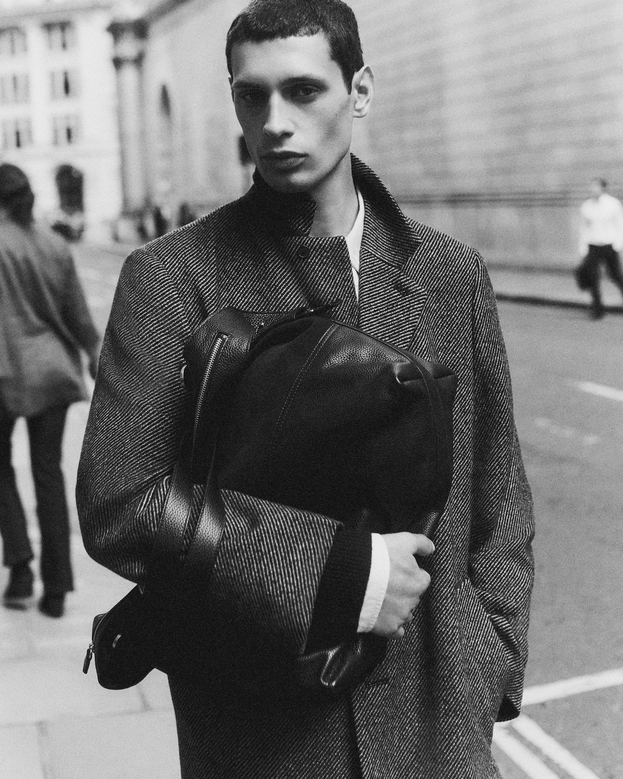 Man walking with a coat and bag in hand