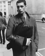 Placeholder for: Man walking with a coat and bag in hand