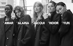 Placeholder for: Five models in oversized black coats stand closely together in a city setting, each with their names written in bold white text.