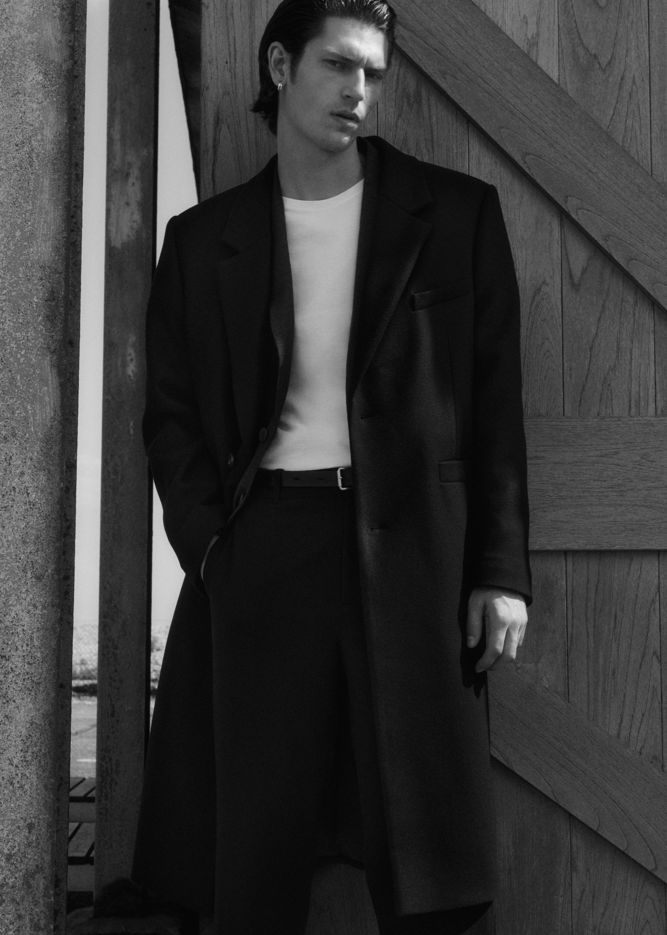 Man wearing smart coat, tshirt and trousers with leather belt