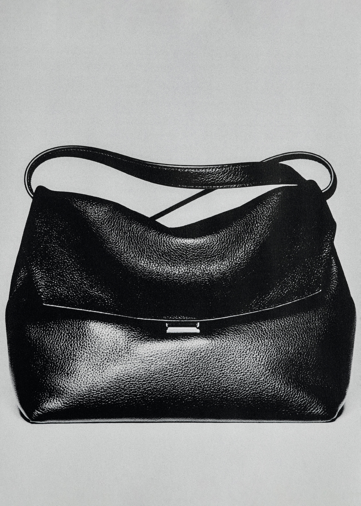 Black leather handbag with a smooth texture and a curved top handle, displayed against a plain background.
