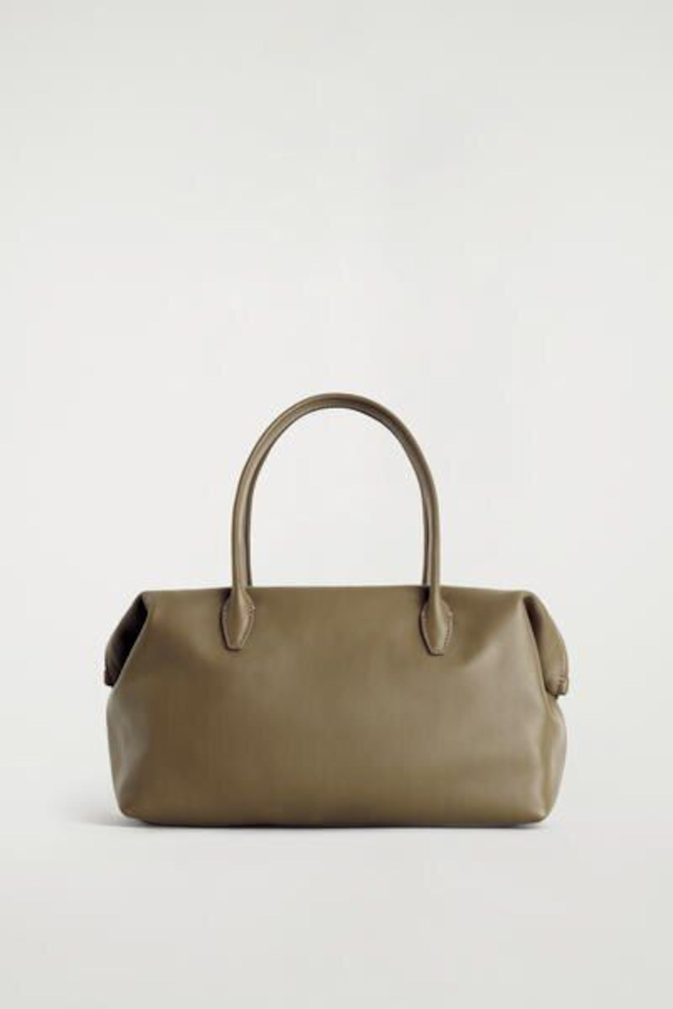 A brown leather handbag with two handles on a plain light background.
