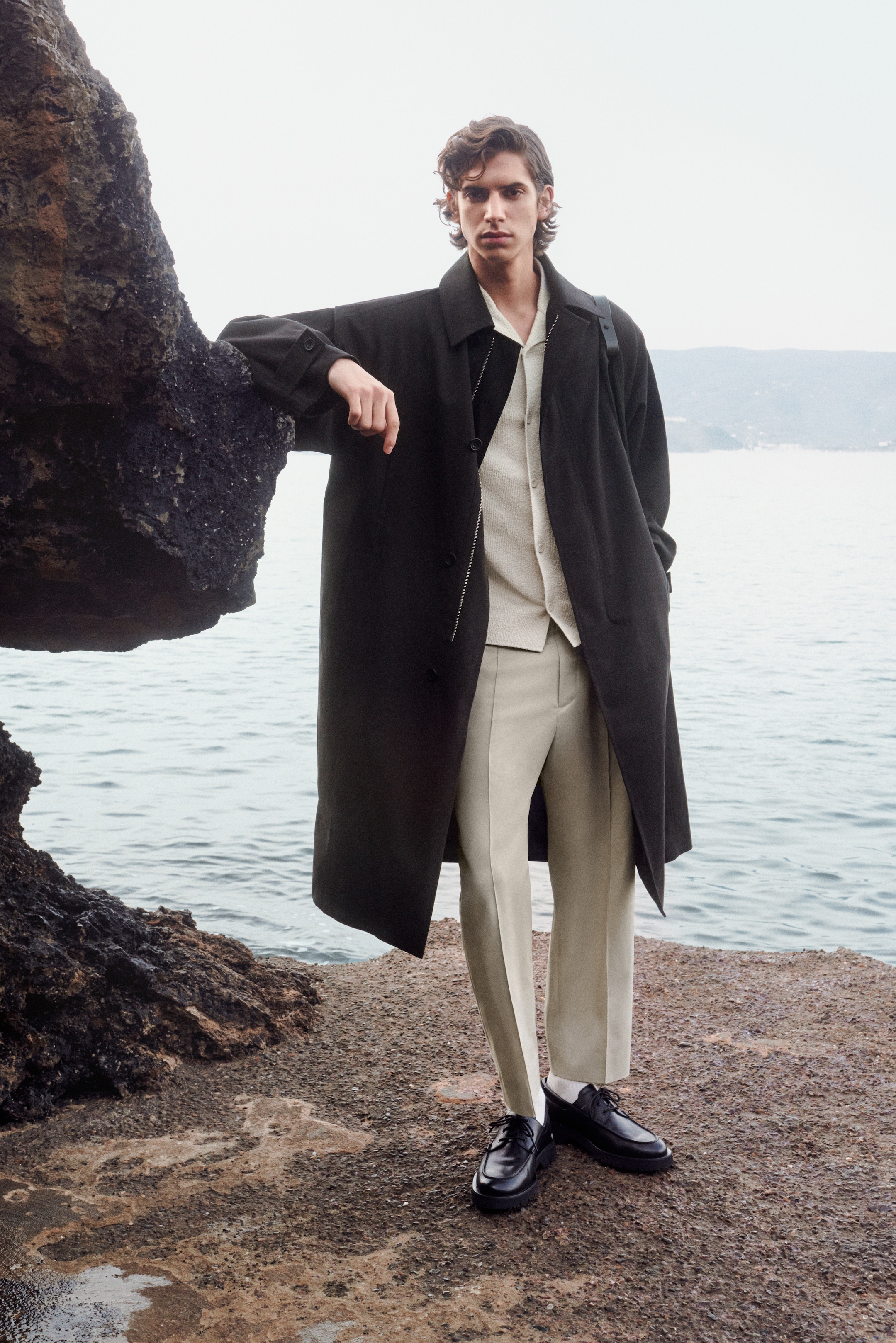 Person wearing beige set and dark coat