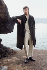 Placeholder for: Person wearing beige set and dark coat