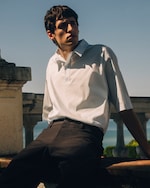 Placeholder for: Man in white shirt and brown trousers leaning back