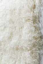 Placeholder for: Close-up of a white, fluffy shaggy fabric texture with intricate, looped fibers creating a soft and textured appearance.