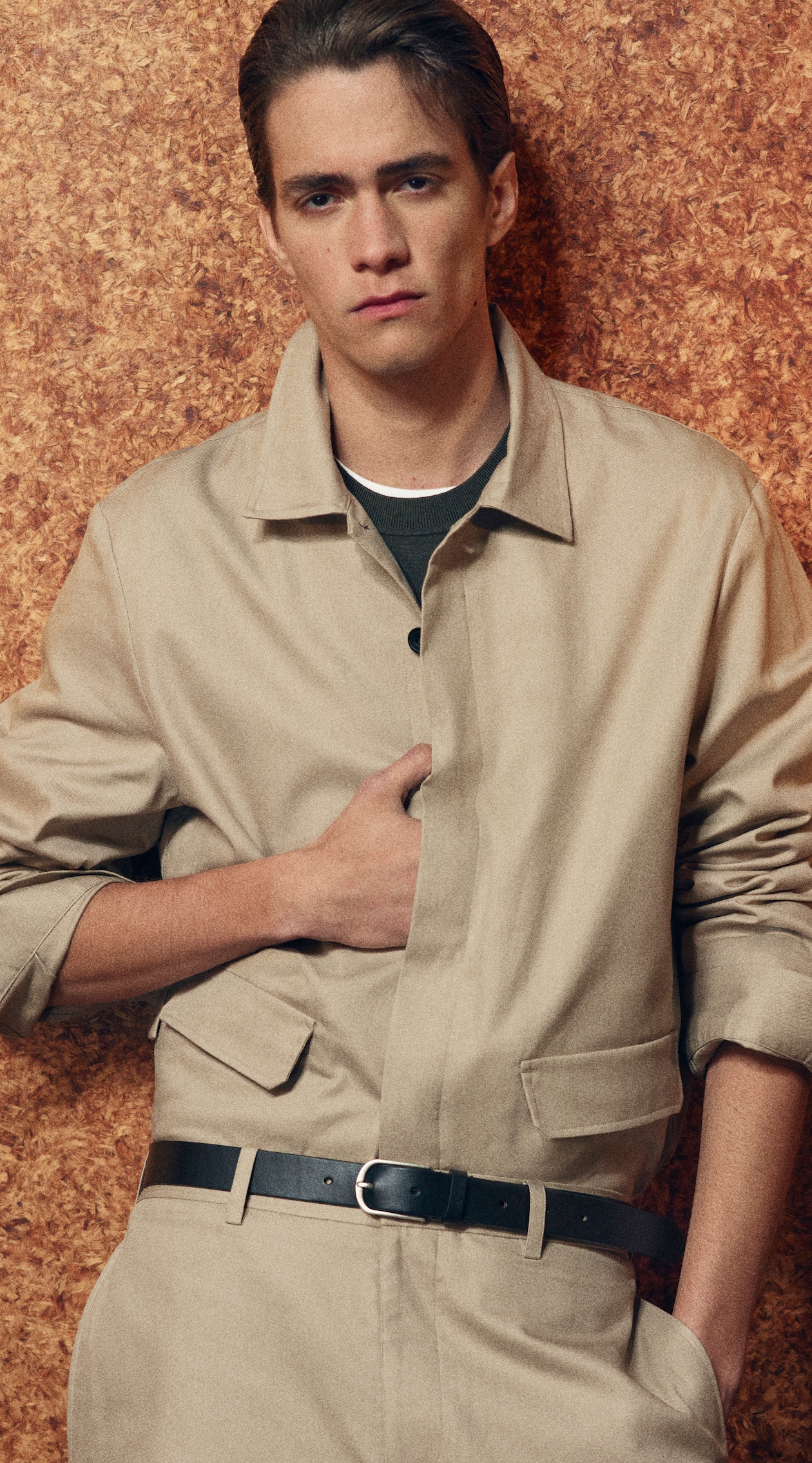 man in coordinating beige shirt and trousers with belt