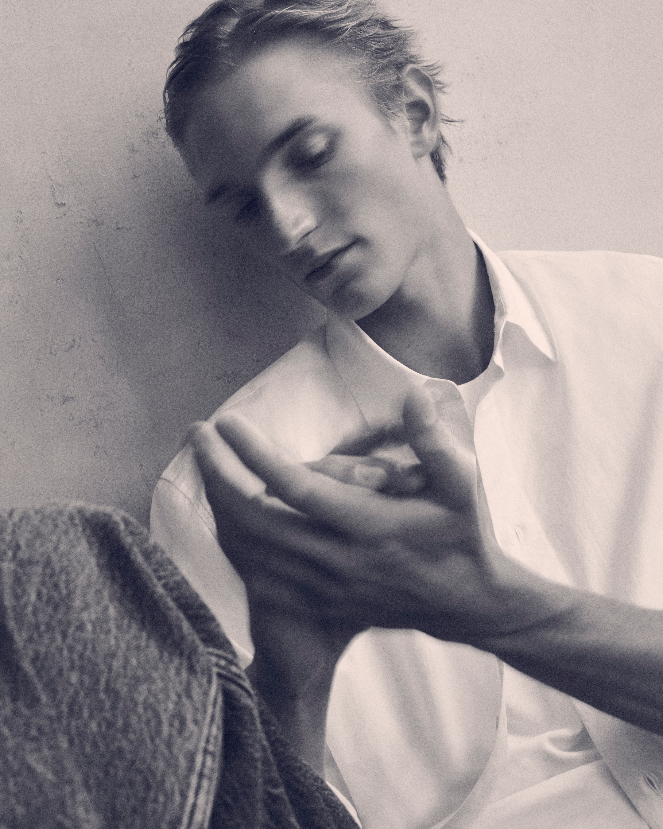 Black & white image of a man in a white shirt & blue jeans