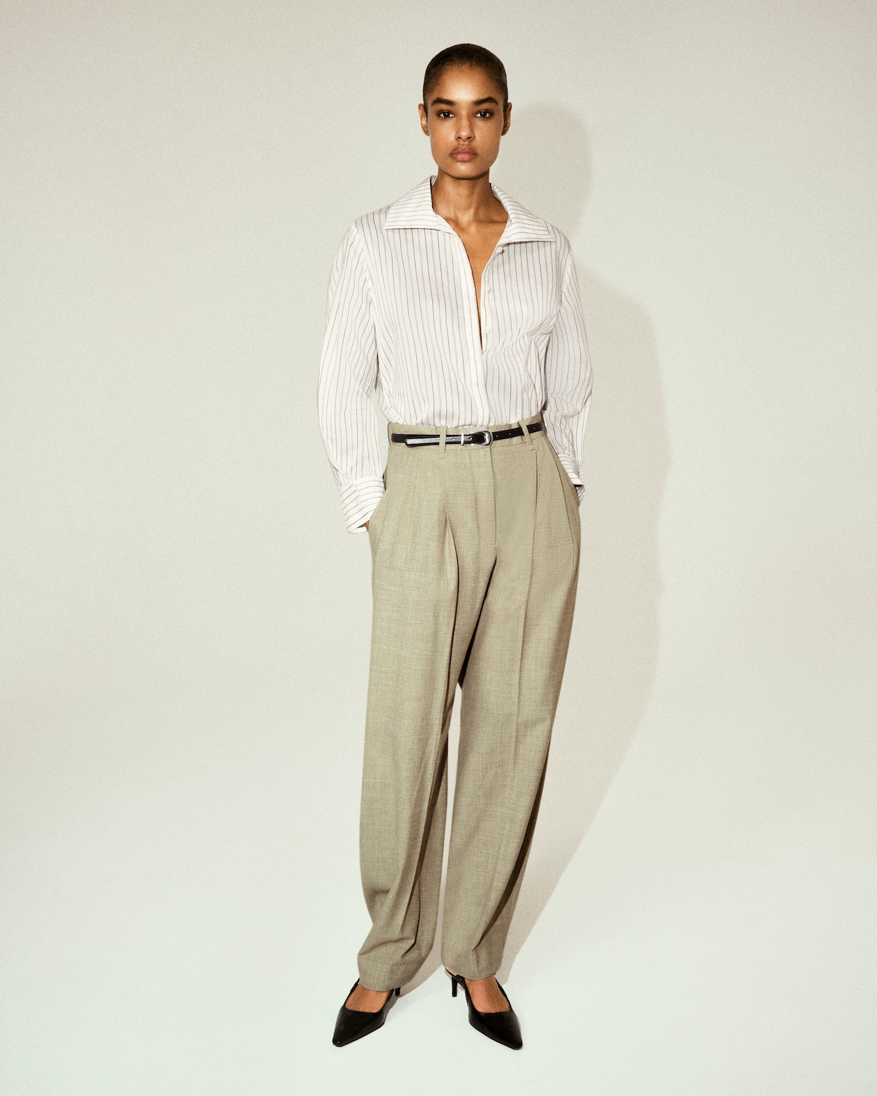 Model in Striped button up shirt and cream trousers