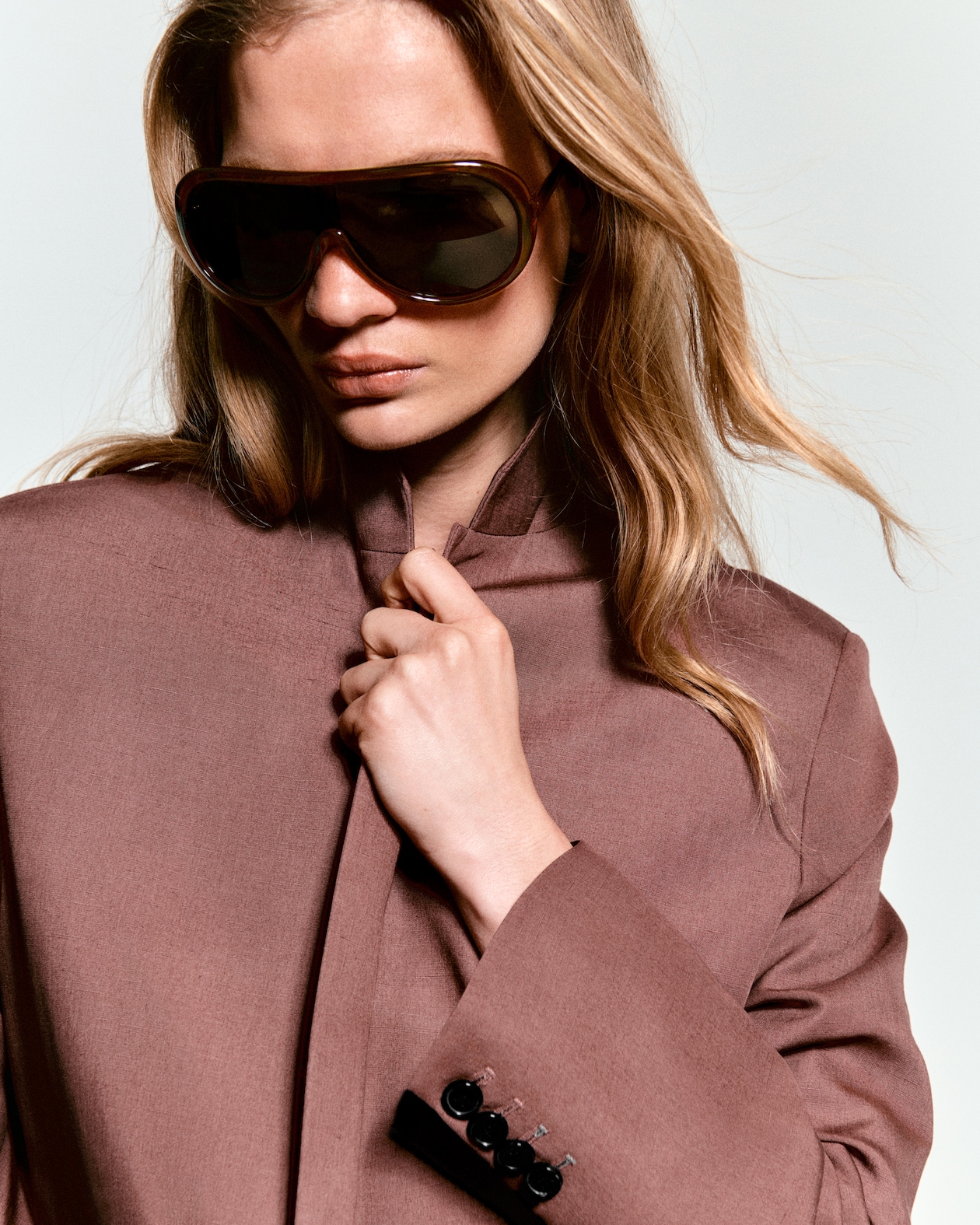 close up of woman in linen blazer wearing sunglasses